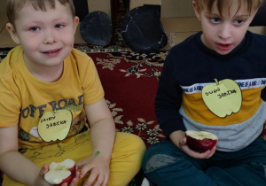 Chłopcy jedzą jabłka